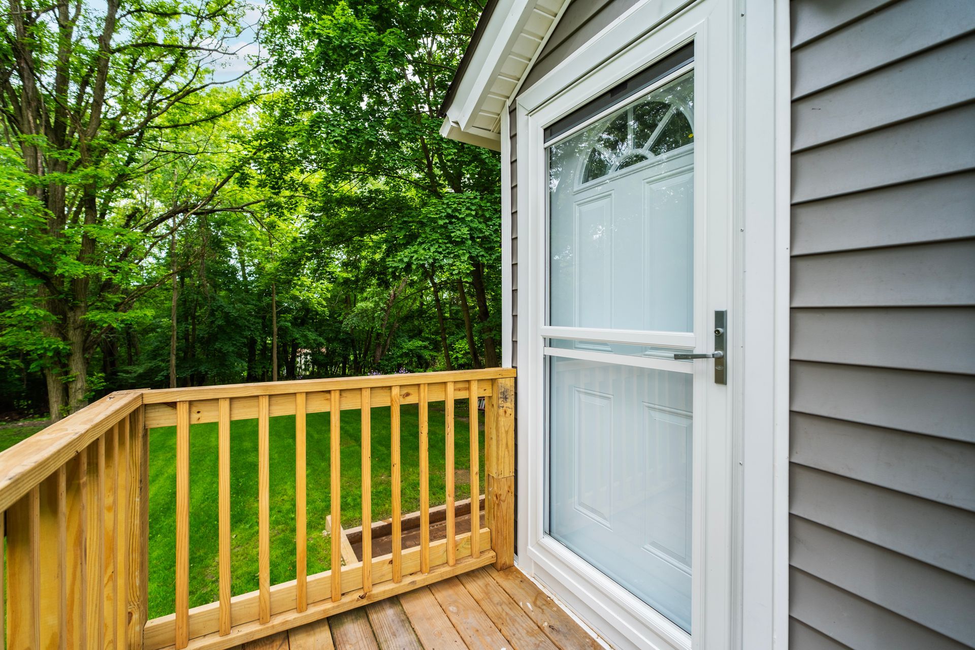 A house with a wooden deck and a sliding glass door.