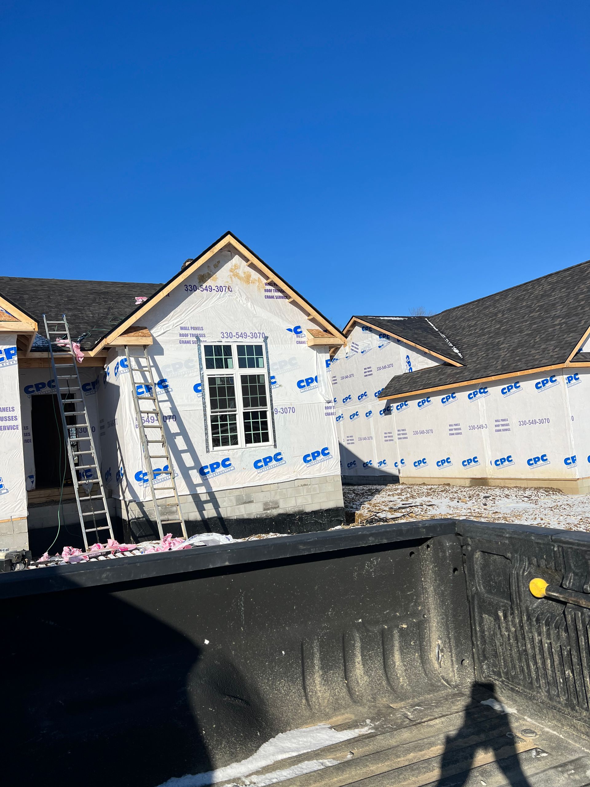 A house is being built with a ladder in front of it.