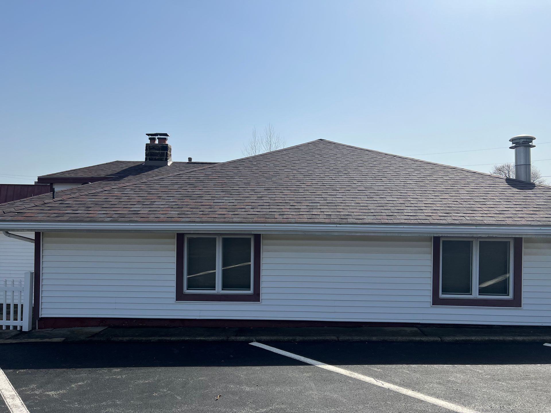 A white house with a brown roof is parked in a parking lot.