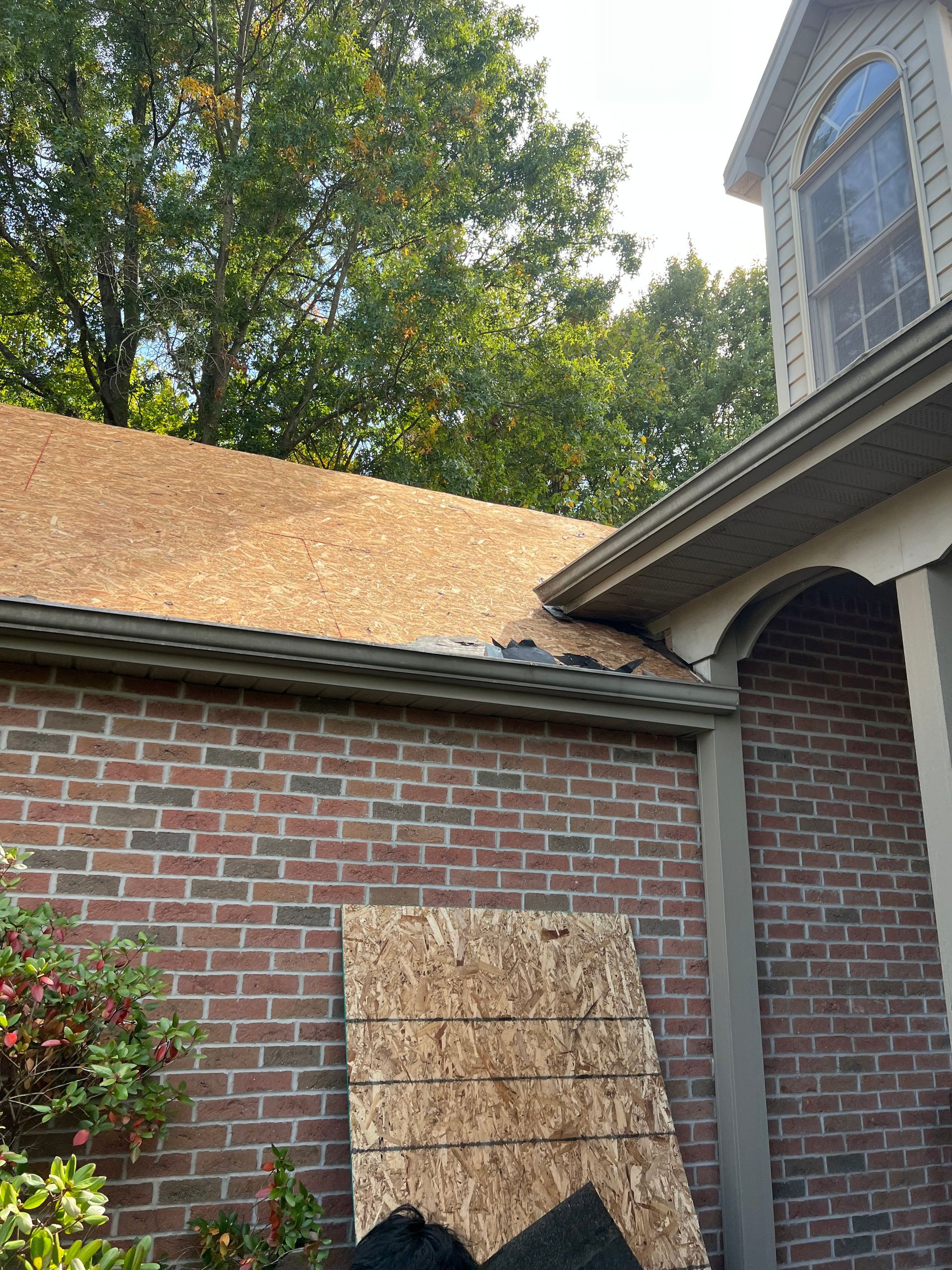A brick building with a roof that is being repaired.