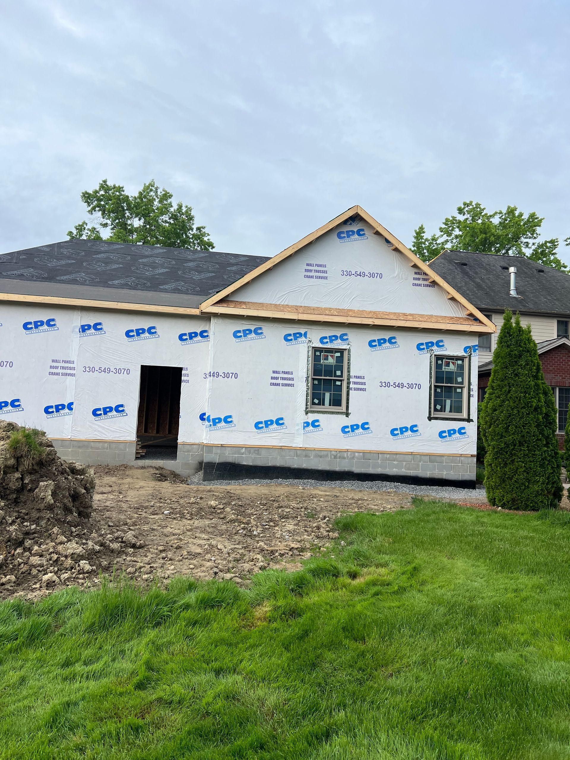 A house is being built in the middle of a lush green field.