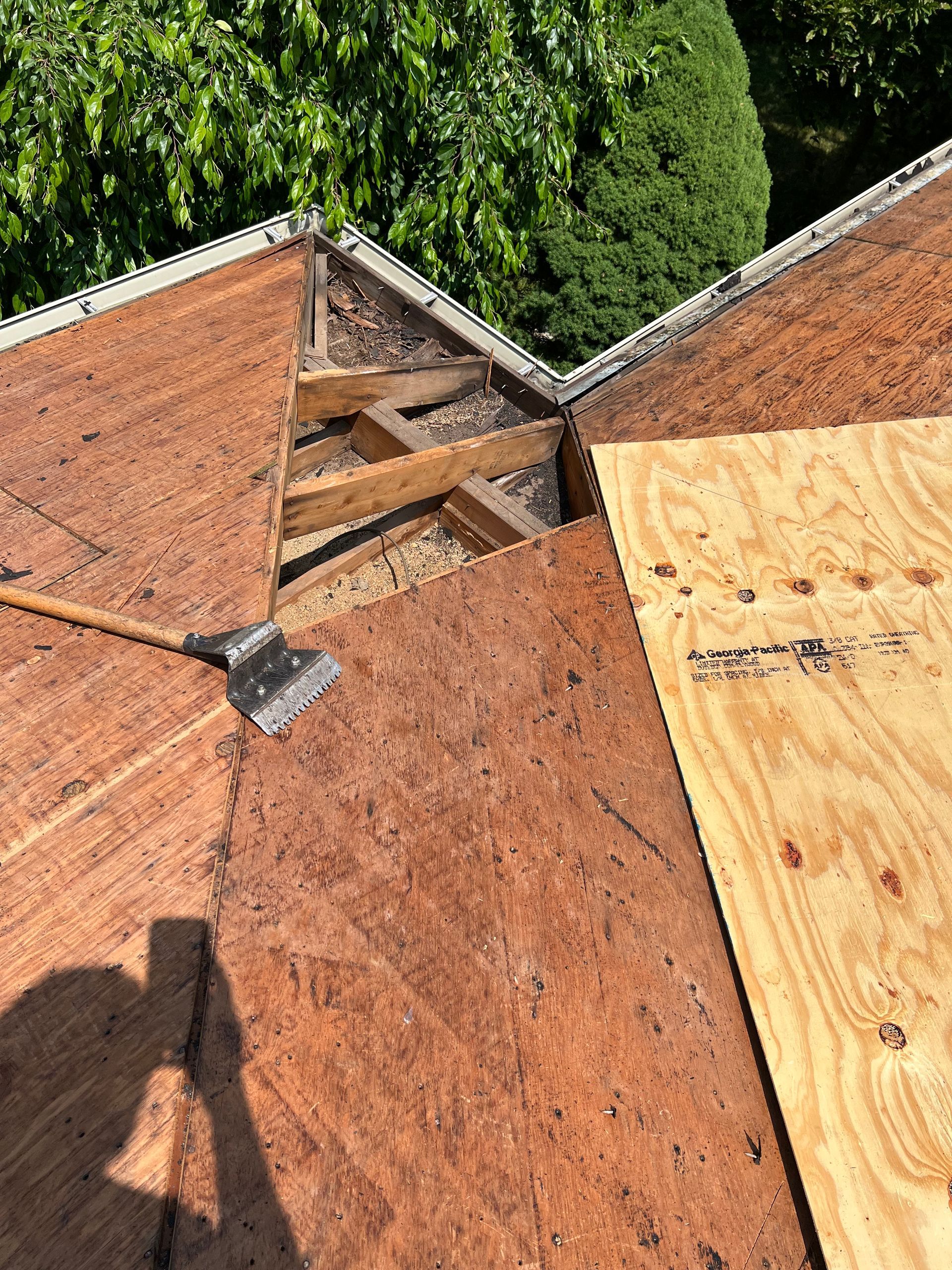 A close up of a roof with a piece of plywood on it.