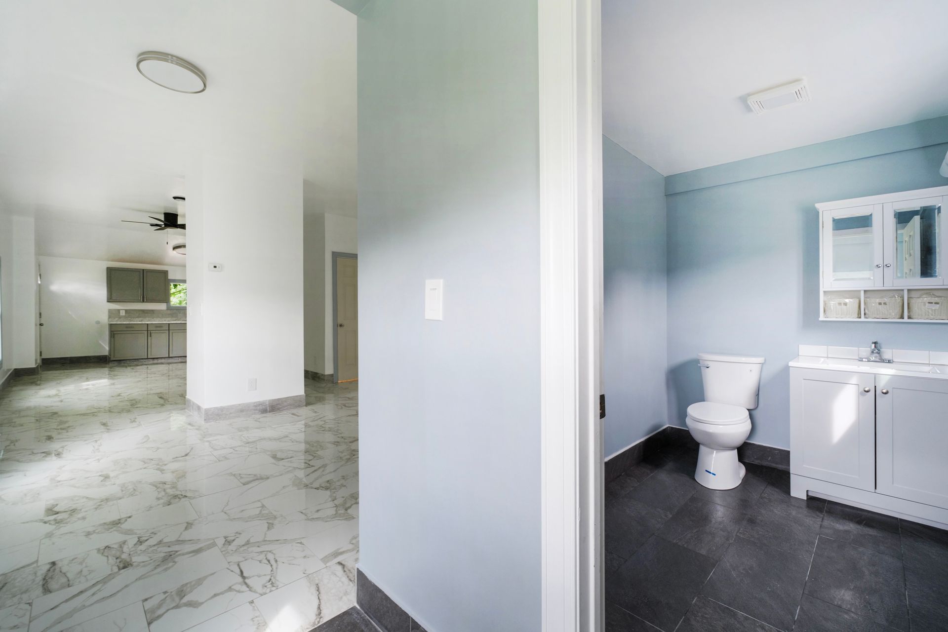 A bathroom with a toilet , sink and mirror.
