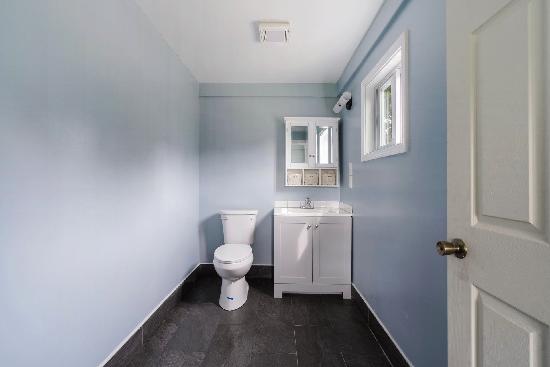 A bathroom with a toilet , sink and mirror