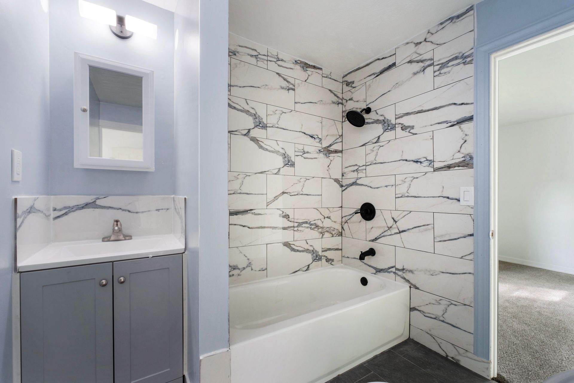 A bathroom with a sink , bathtub and shower.