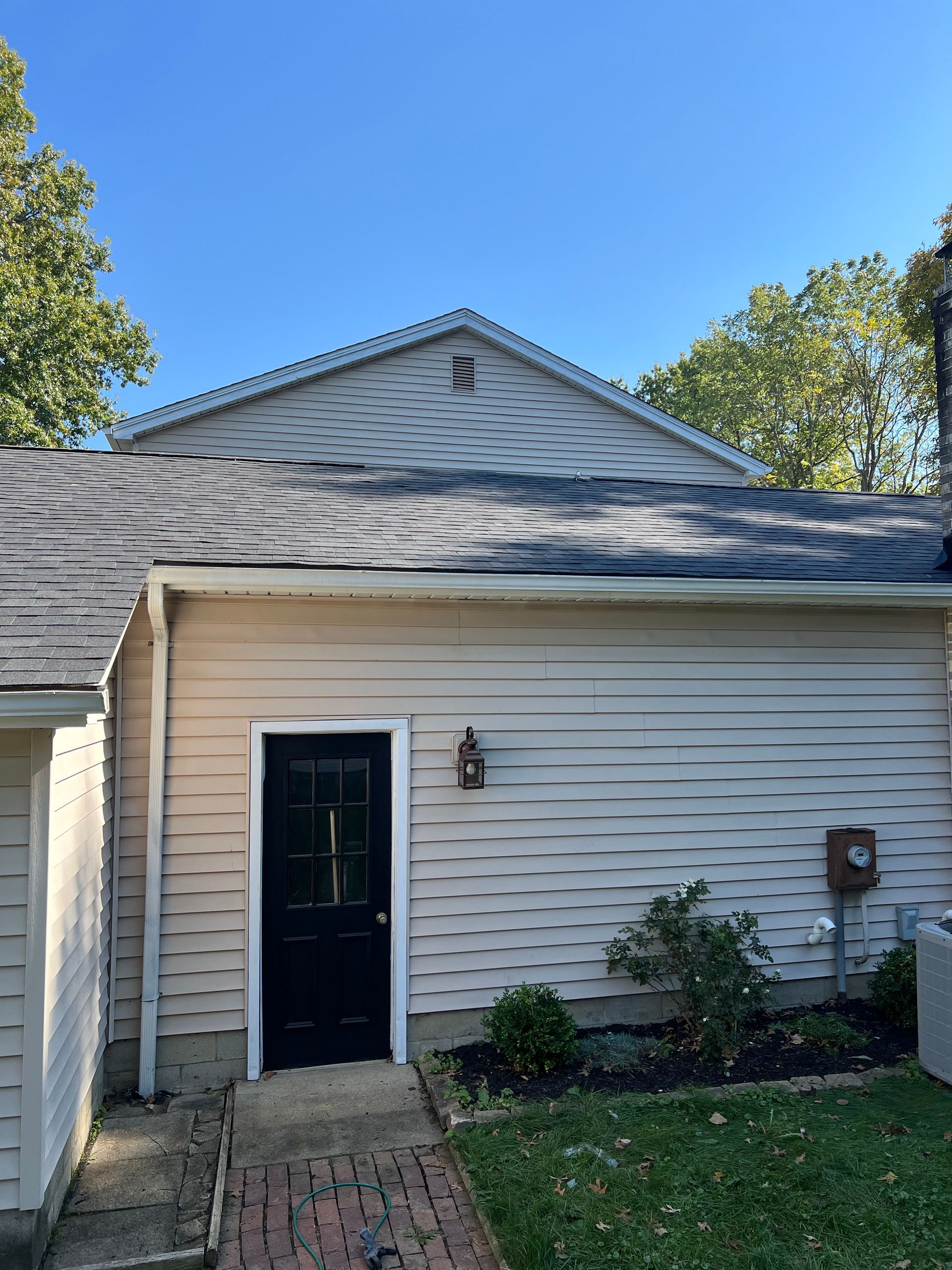 A white house with a black door and a blue sky in the background