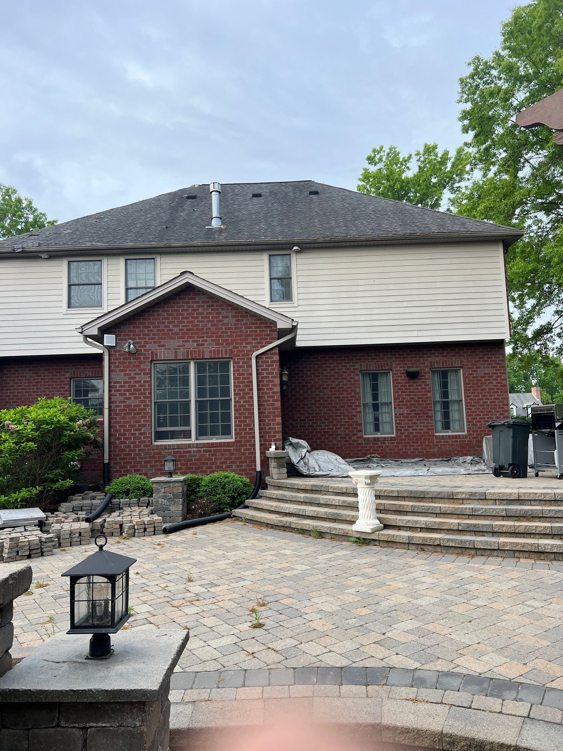 A large brick house with a patio in front of it.