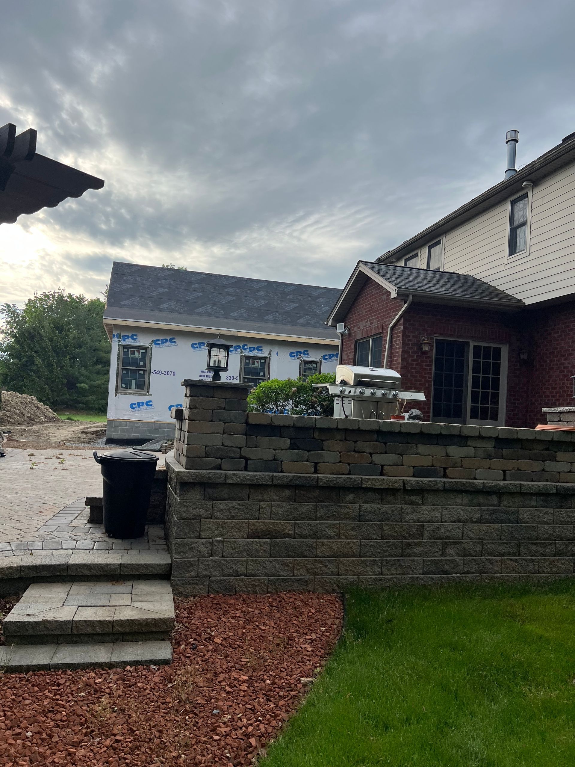 A house with a brick wall in front of it is being built.
