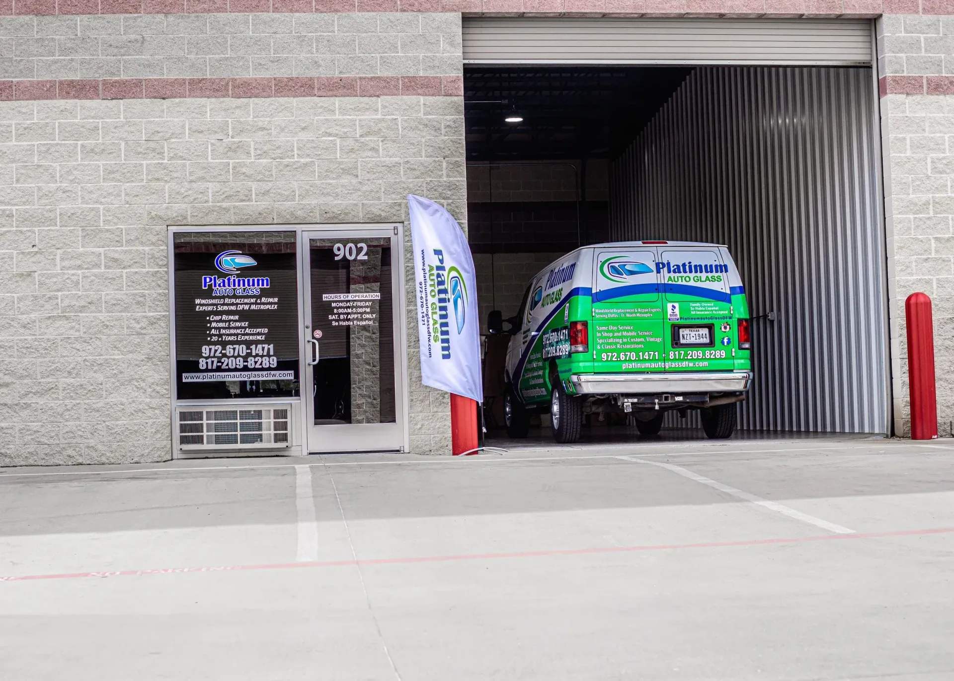 A green and white van entering a building, doorway with a storefront and open door, brick exterior.