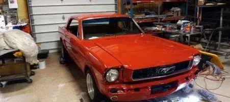 Bright red classic Mustang in a garage.