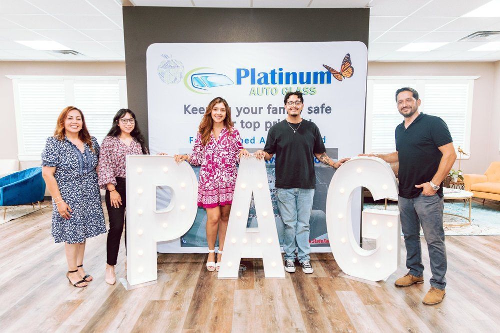 Five people stand holding light-up letters spelling