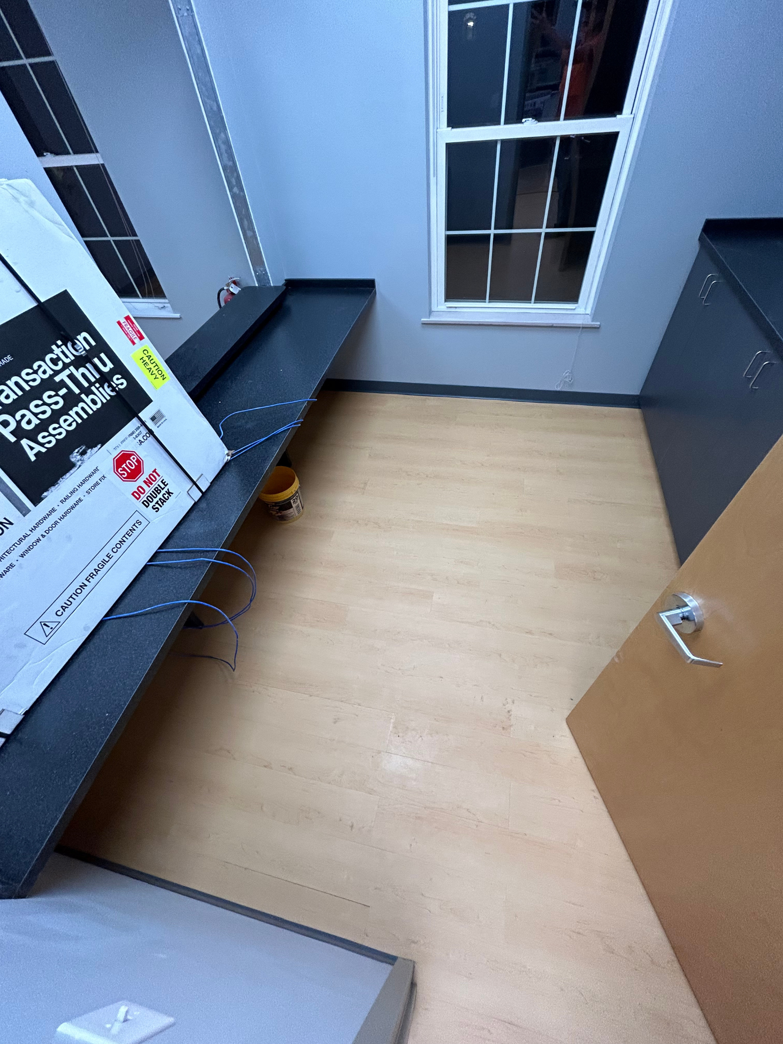 Small room with two desks, a wooden floor, and a door opening into the space.