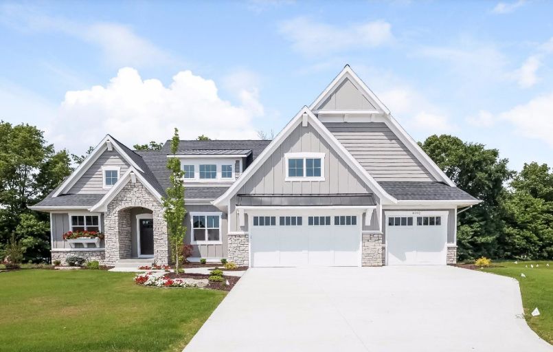 Gray Craftsman-style house with white trim, two-car garage, and a long driveway.