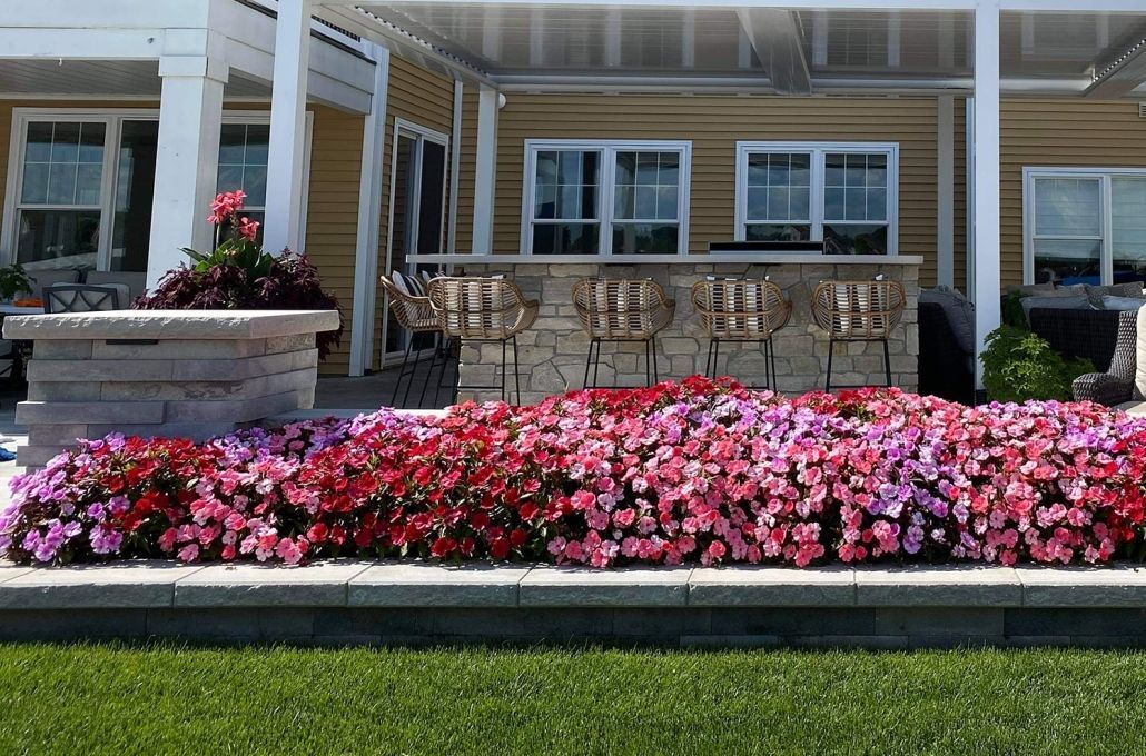 A house with a patio and flowers in front of it