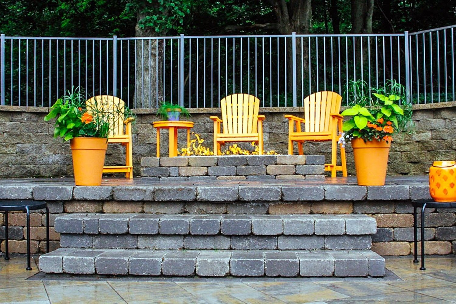 A patio with stairs and chairs and potted plants