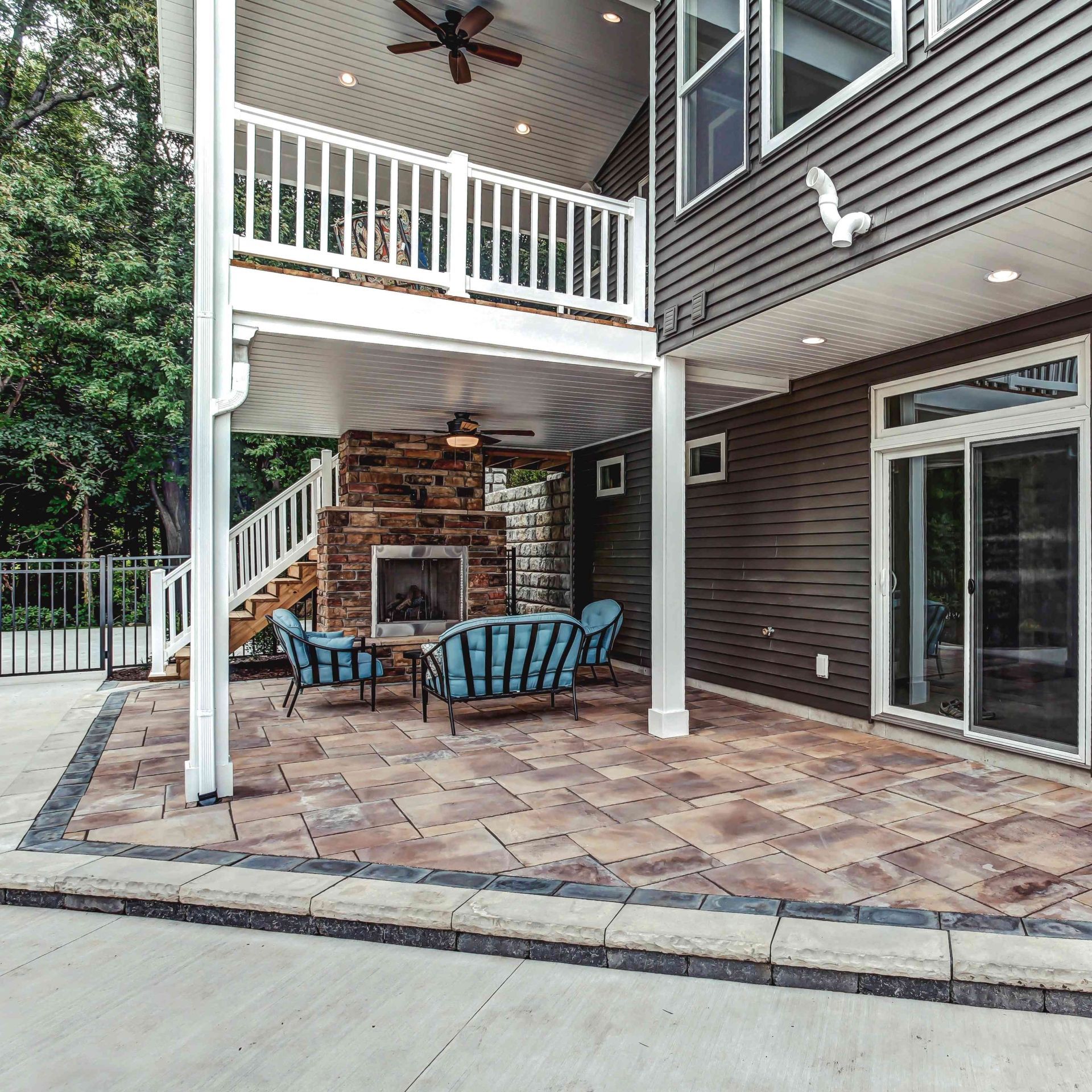 The backyard of a house with a patio and a fireplace.