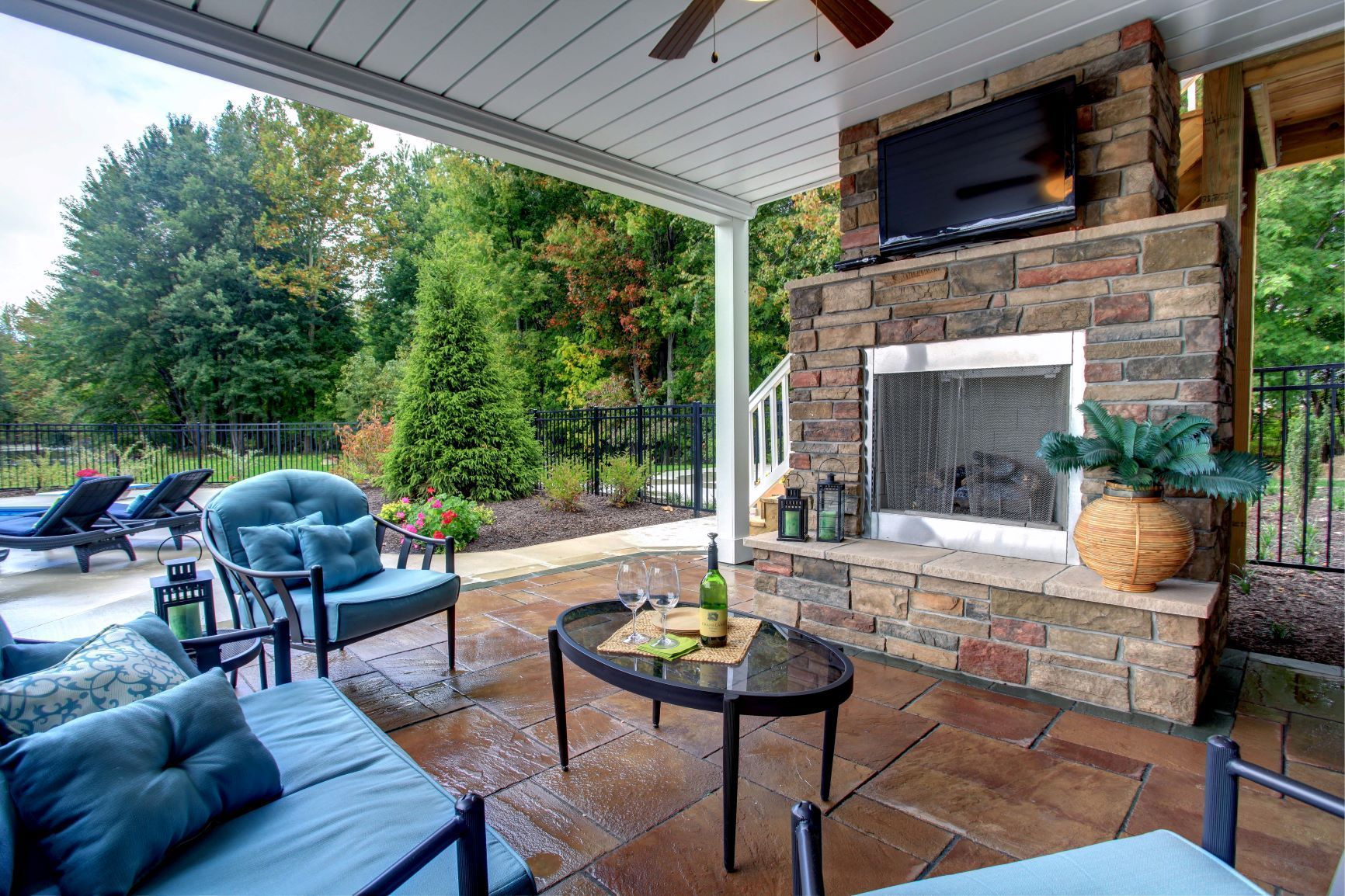 A patio with a fireplace and a flat screen tv.