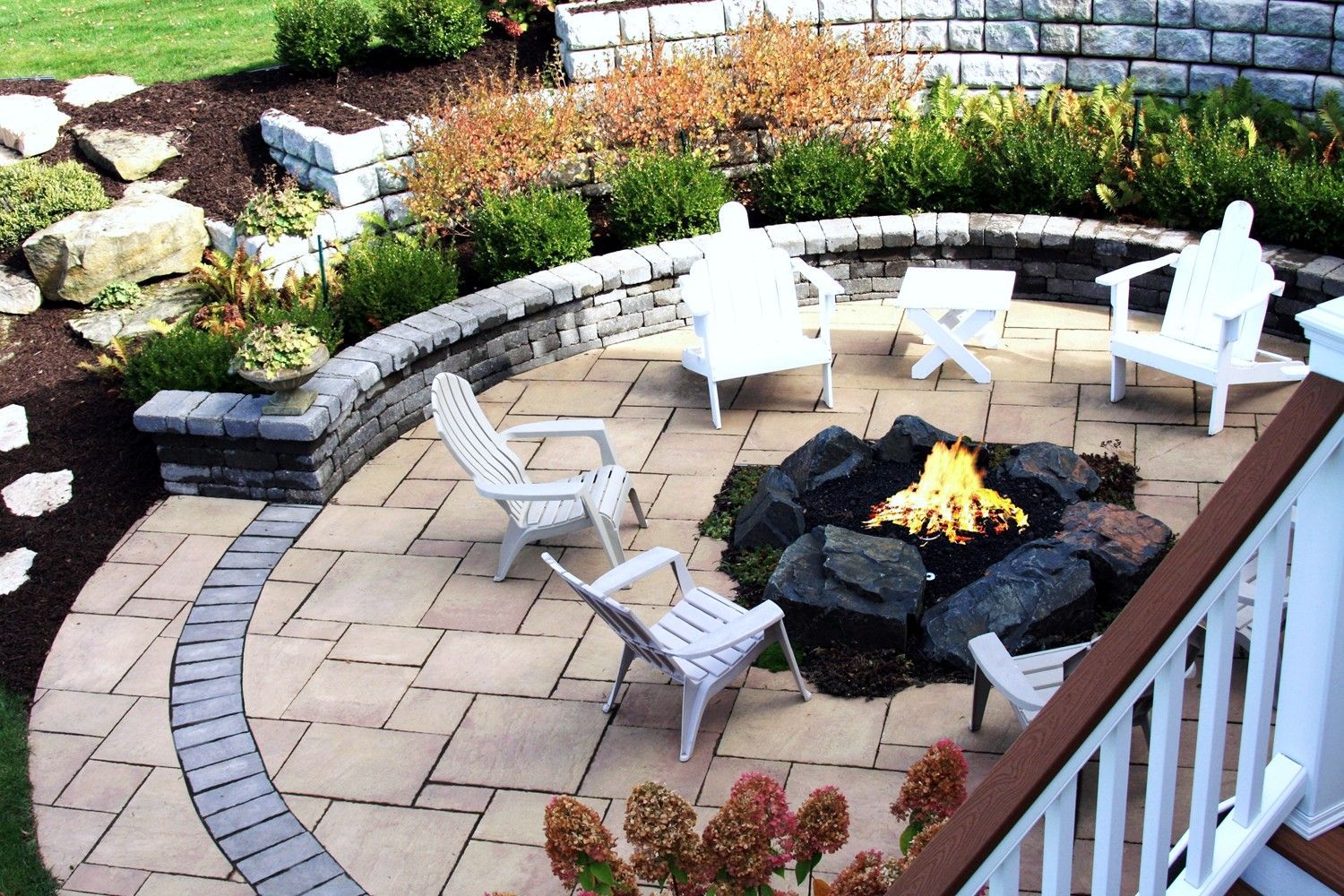 A patio with chairs and a fire pit in the middle