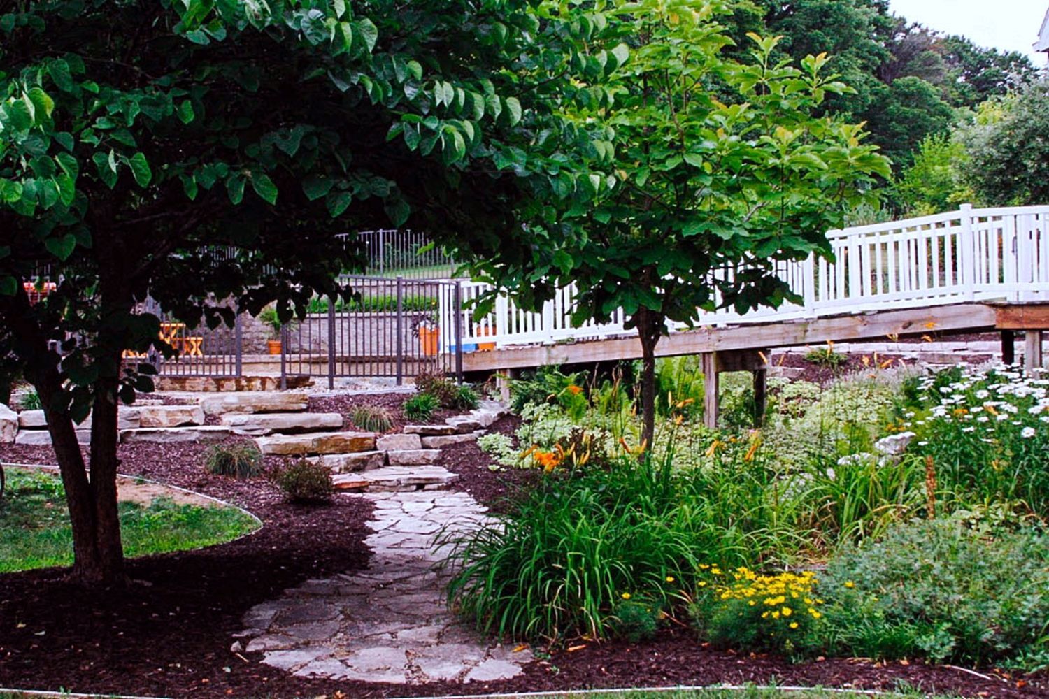 A stone path leading to a bridge in a garden