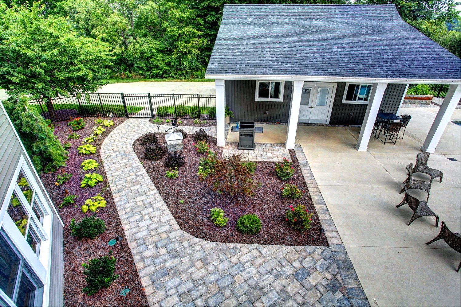 An aerial view of a house with a covered patio and a walkway leading to it.
