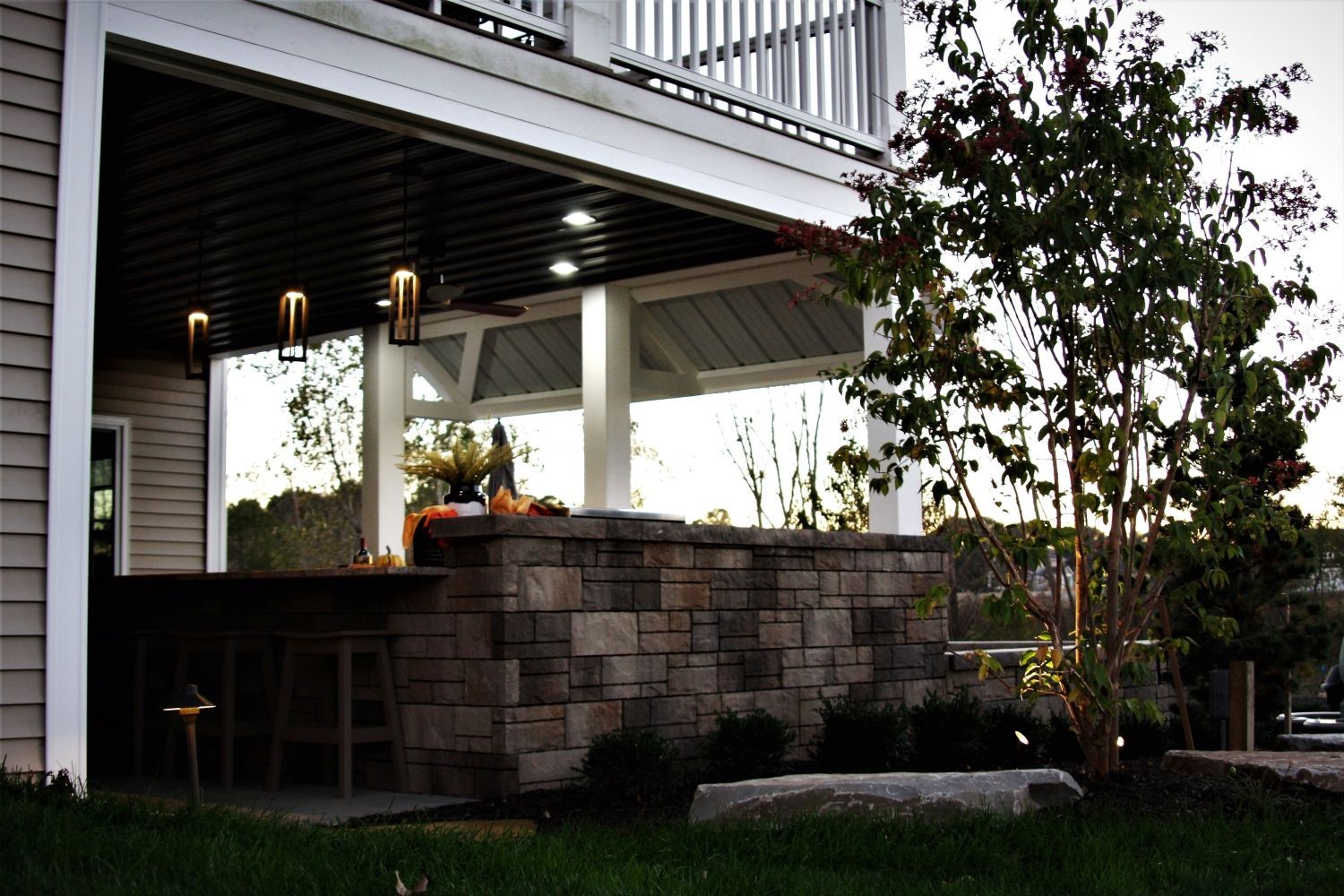 A house with a covered porch and a stone wall