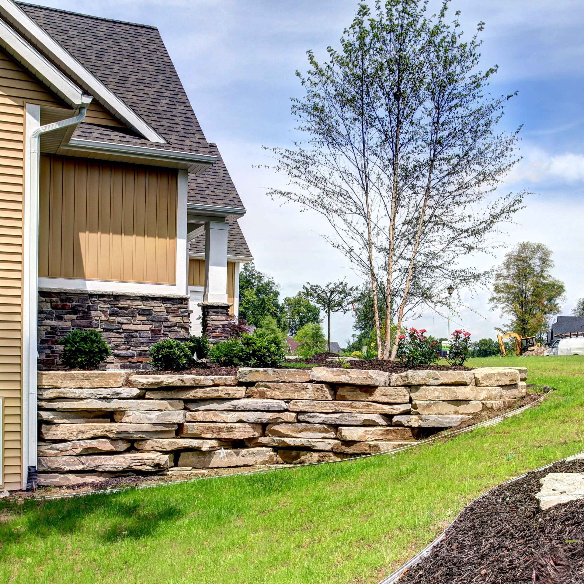 A house with a stone wall in front of it