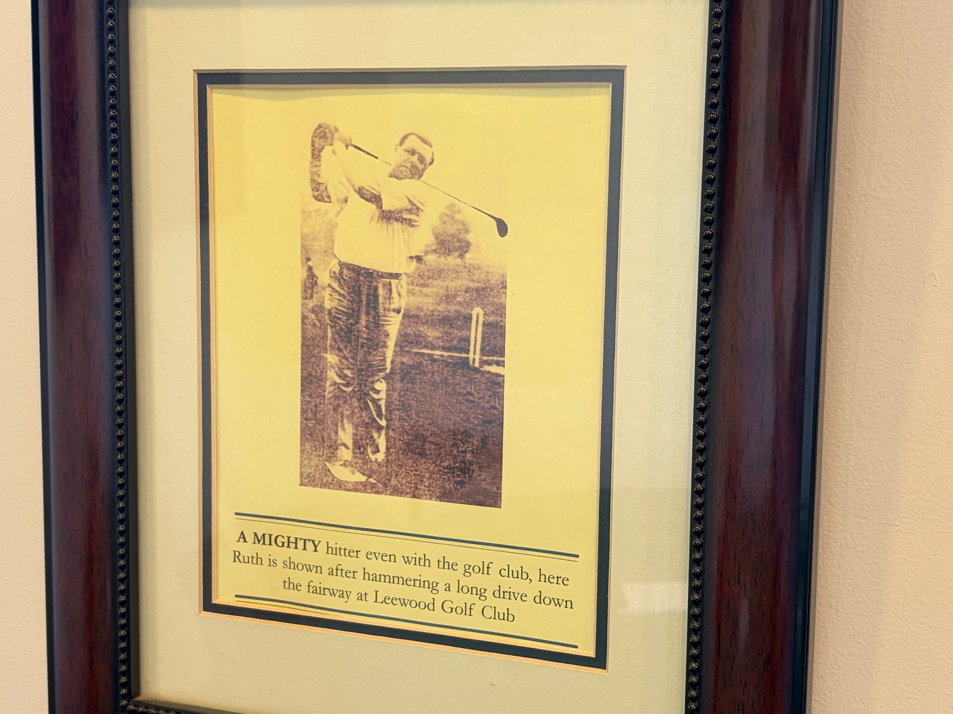 Framed vintage sepia photograph of a golfer mid-swing with a caption below