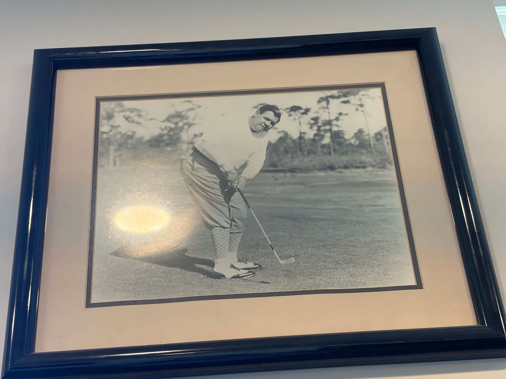 Framed black-and-white photo of a golfer mid-swing on a course