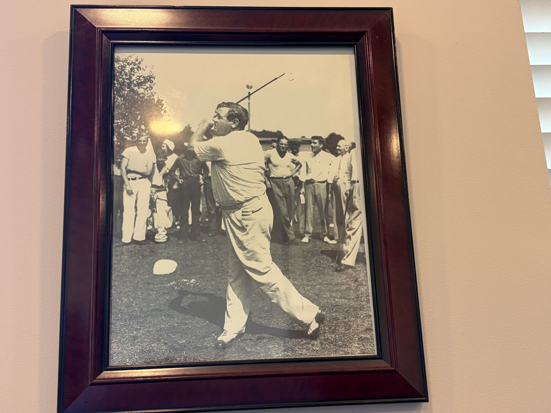 Framed black-and-white photo of a golfer mid-swing with spectators in the background