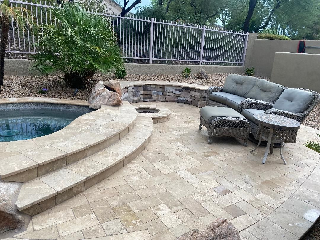 A patio with a couch and chairs next to a pool.