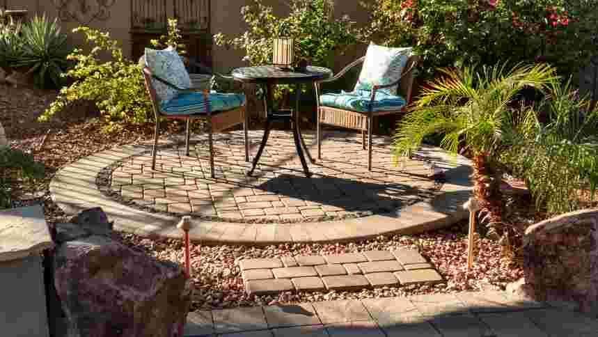 A patio with a table and chairs in the middle of it.