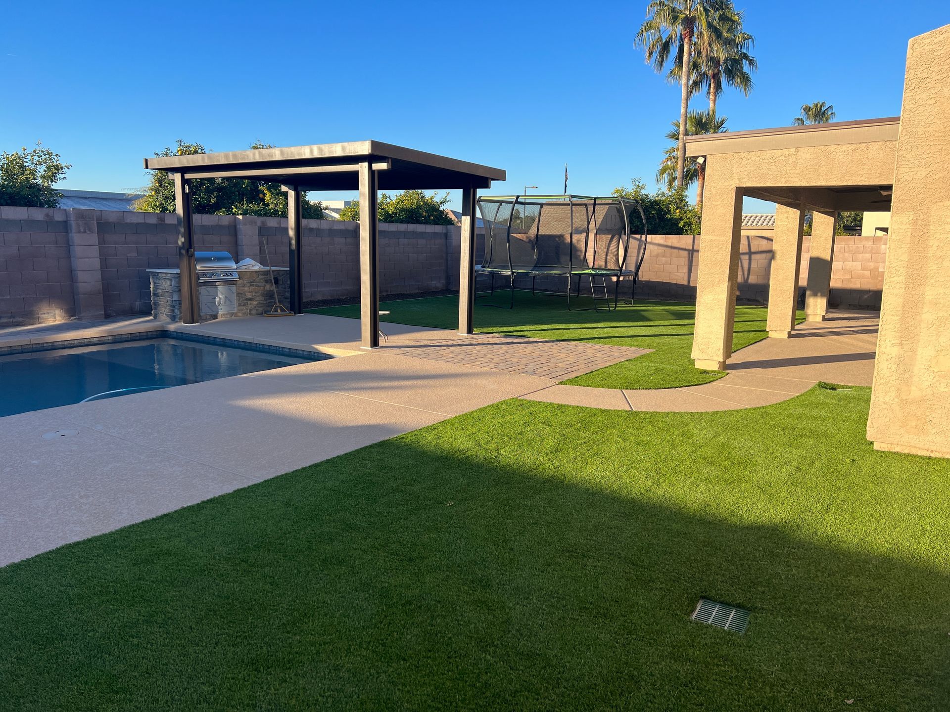 A backyard with a swimming pool and a pergola