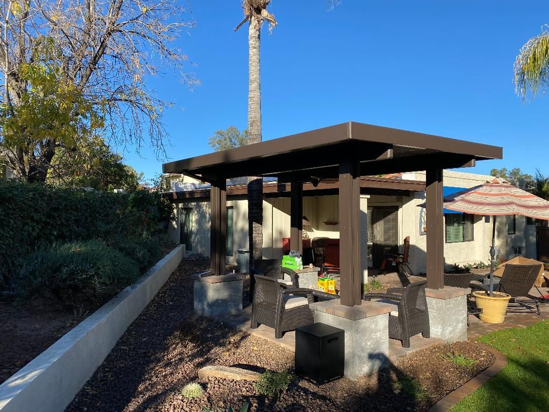There is a pergola in the backyard of a house.