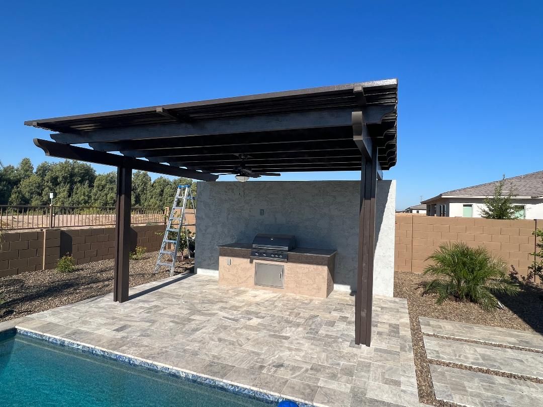A pergola is sitting next to a swimming pool.