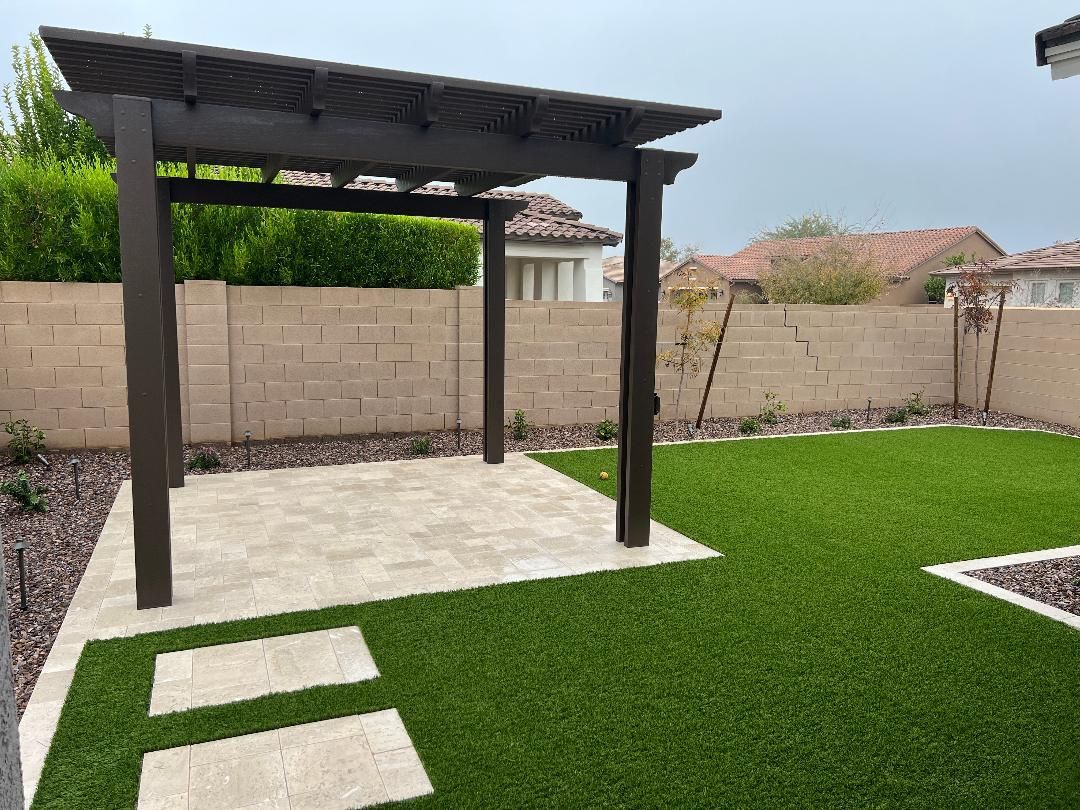 There is a pergola in the middle of the backyard.