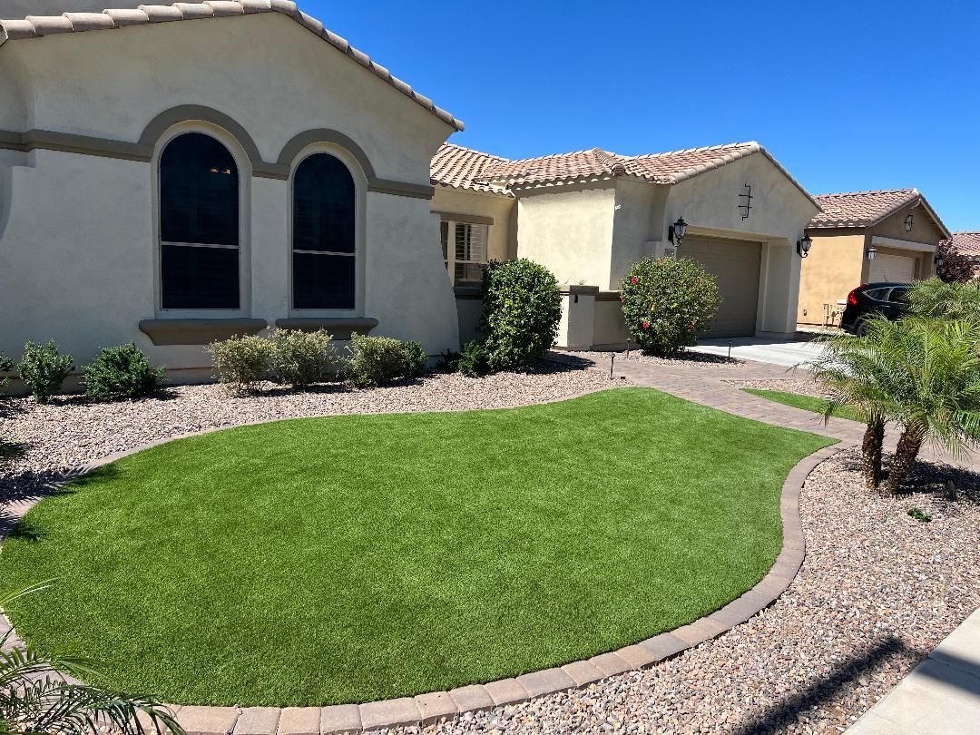 A house with a circular lawn in front of it.