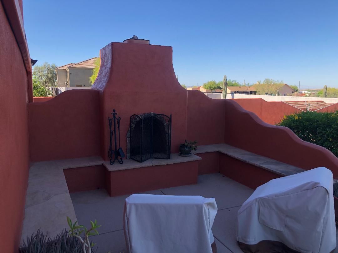 There is a fireplace in the backyard of a house.