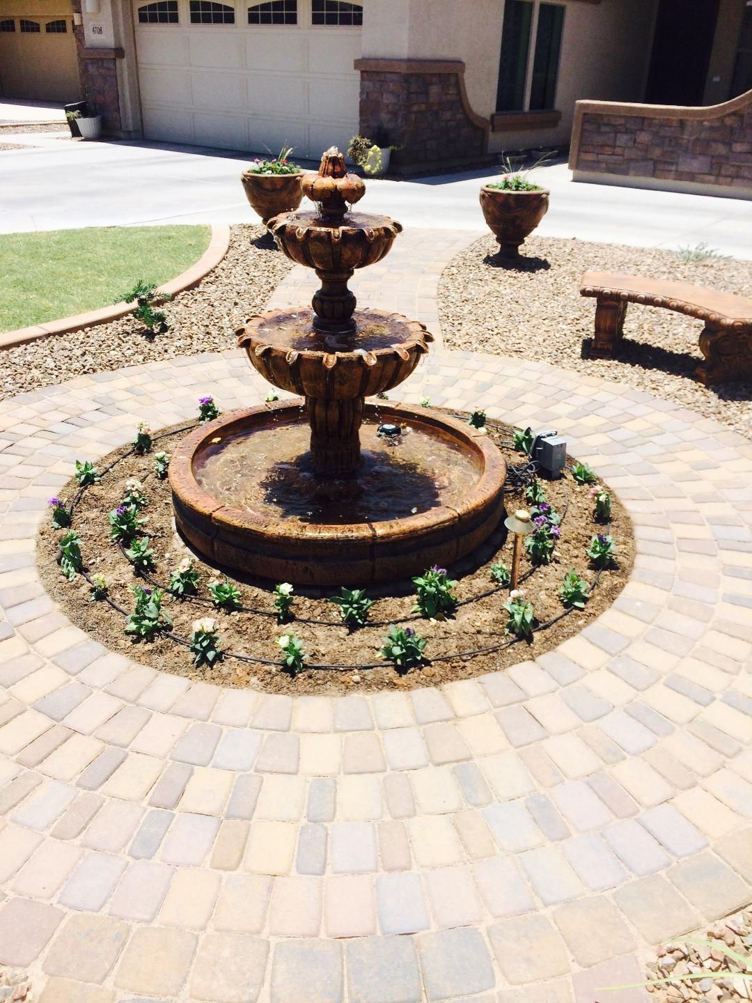 A fountain in the middle of a brick patio