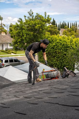 Worker repairing a shingled roof