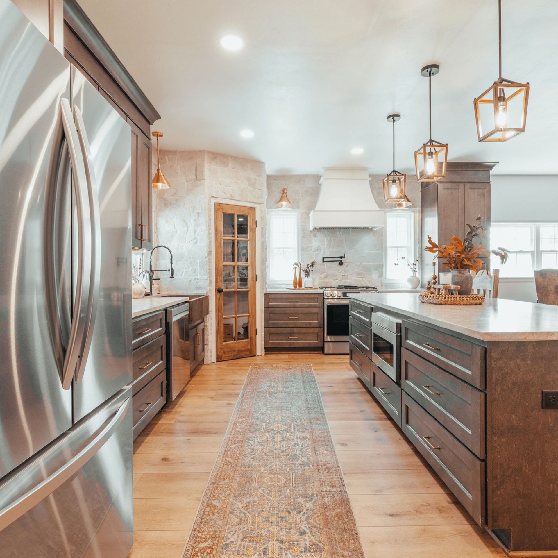 Modern kitchen with stainless steel appliances, wood cabinets, and large island.