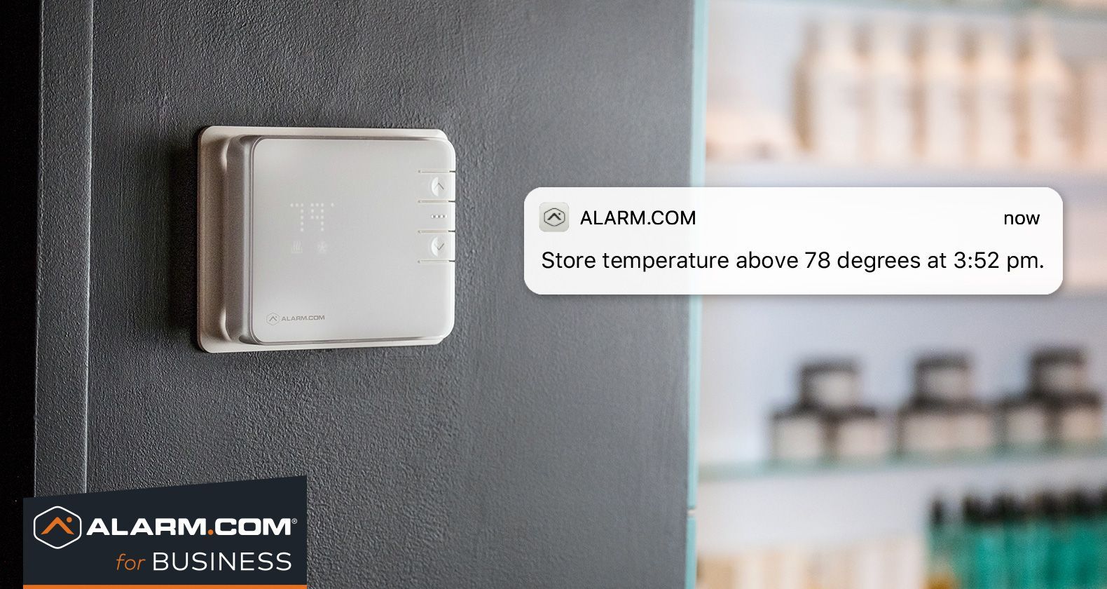 A white box is sitting on a wall next to a sign that says alarm com business.