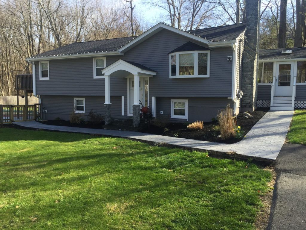 A large gray house with a ramp leading to the front door.