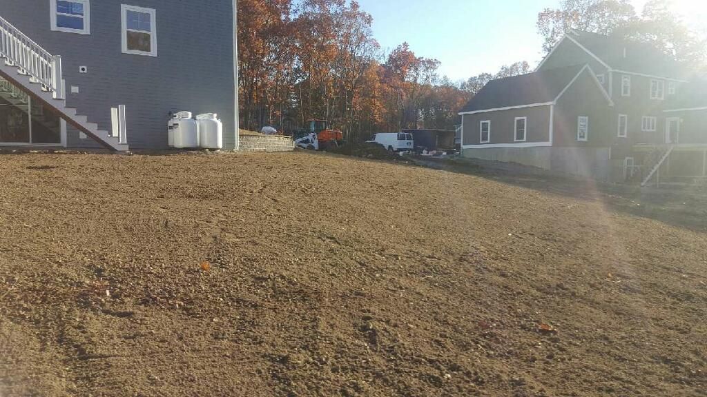 A large pile of dirt is in front of a house.