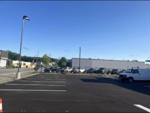 A white van is parked in a parking lot next to a building.