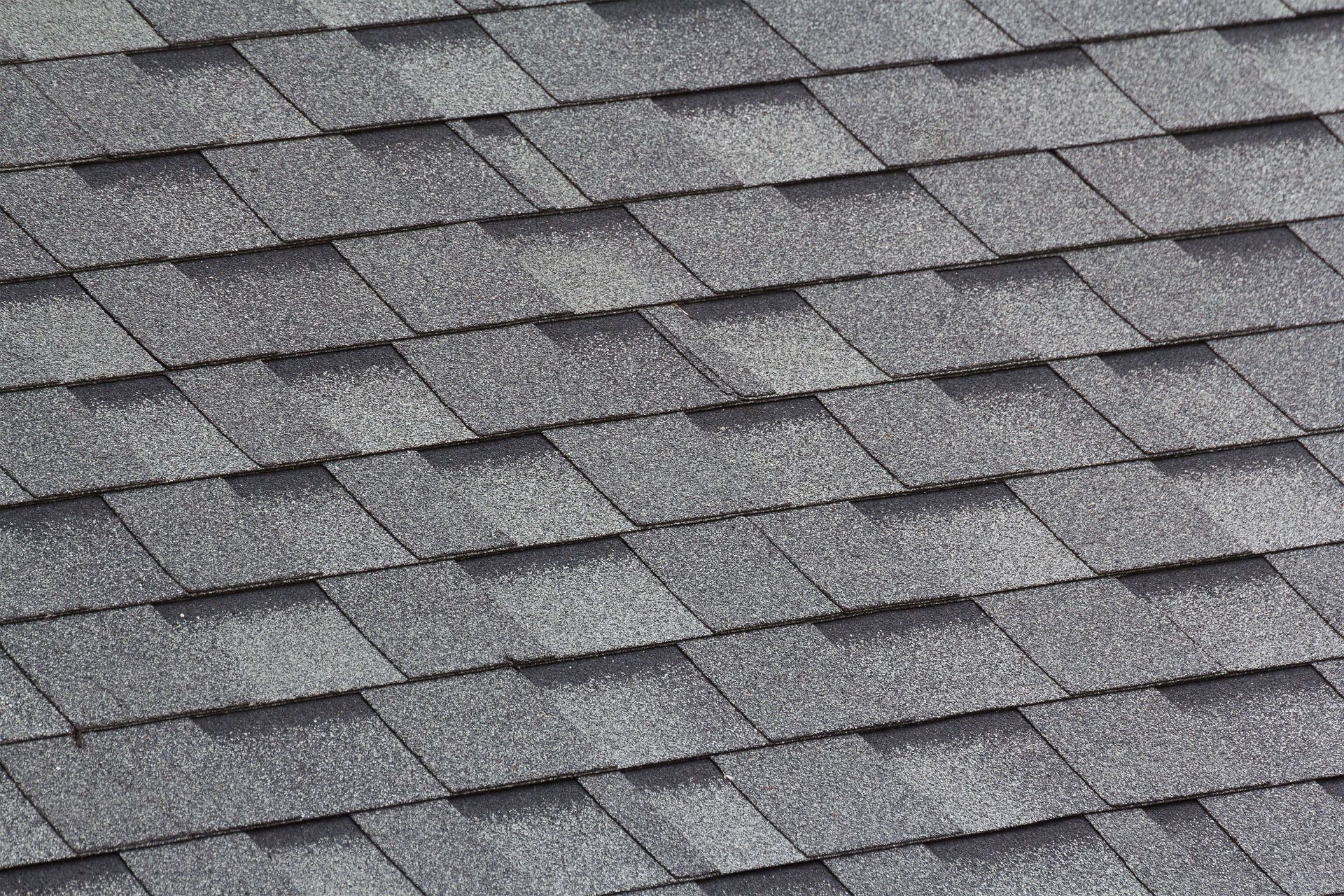 Gray asphalt roof shingles in a diagonal pattern.