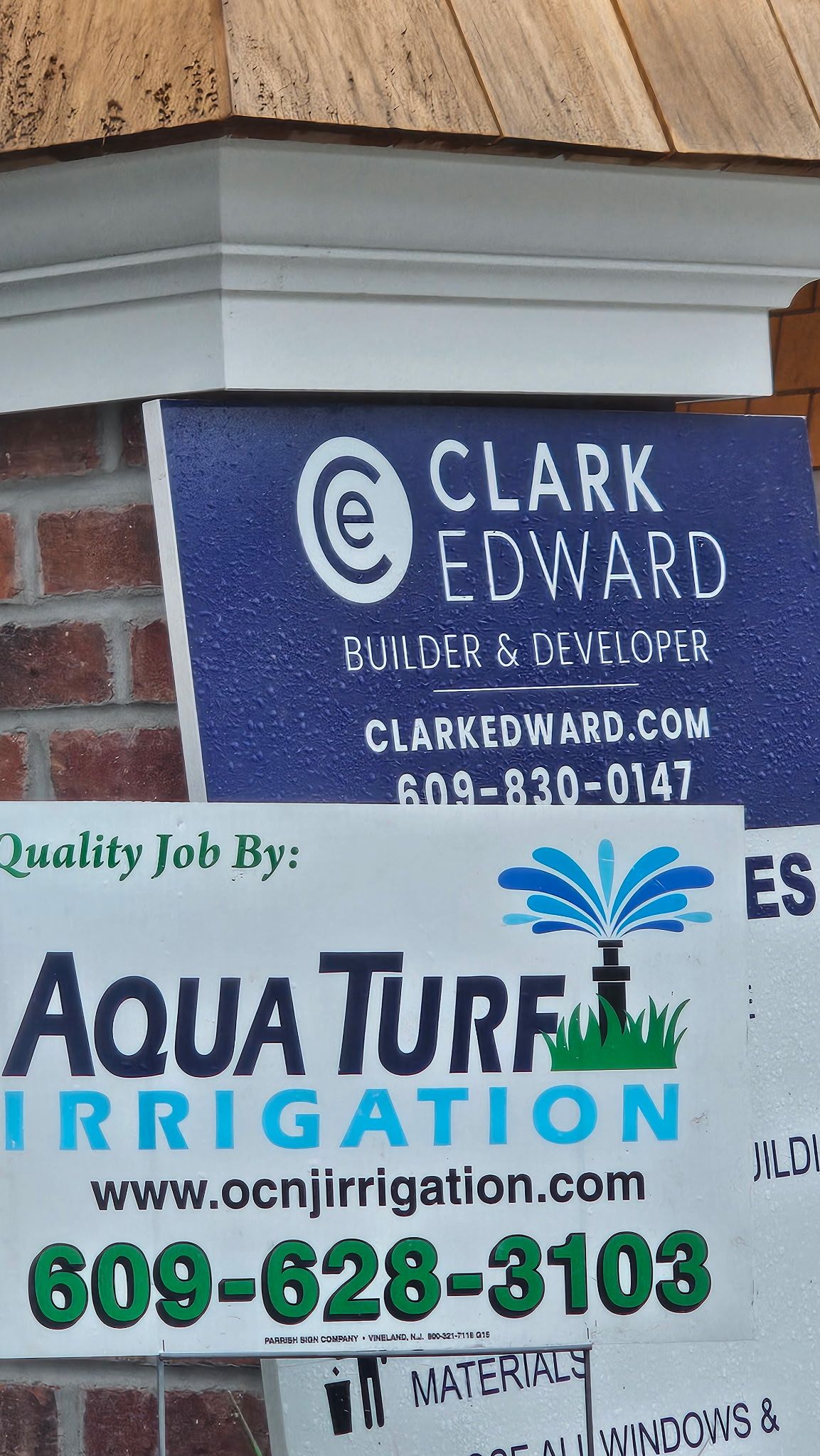 Signs for Clark Edward and Aqua Turf Irrigation with contact information.