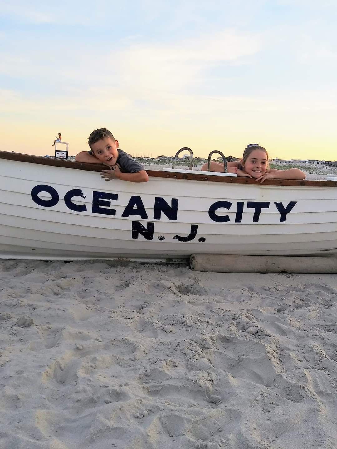 Two children in a boat that says 