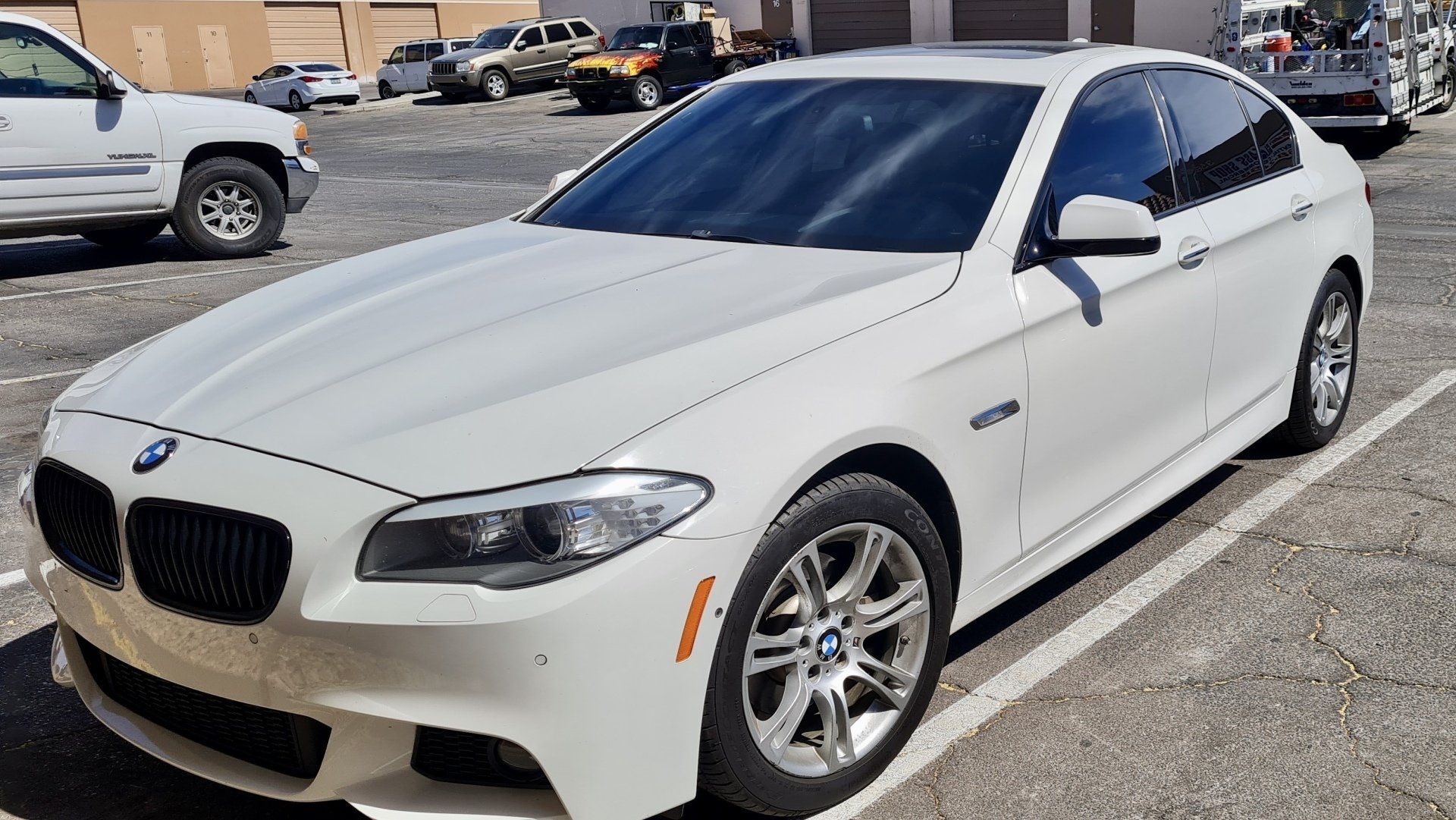 a white BMW is parked in a parking lot.