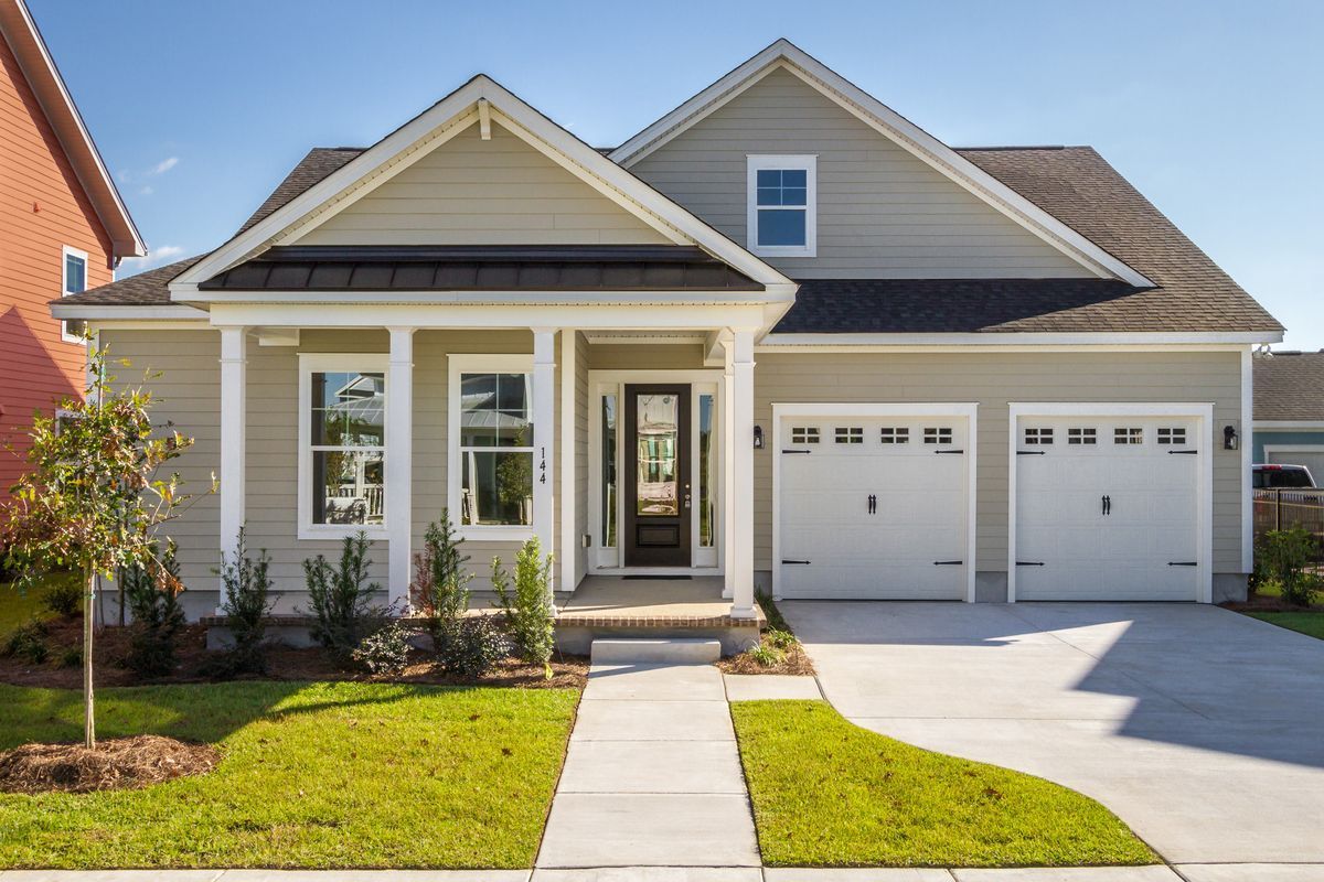 Light green house with white trim, two-car garage, and a walkway to the front door.