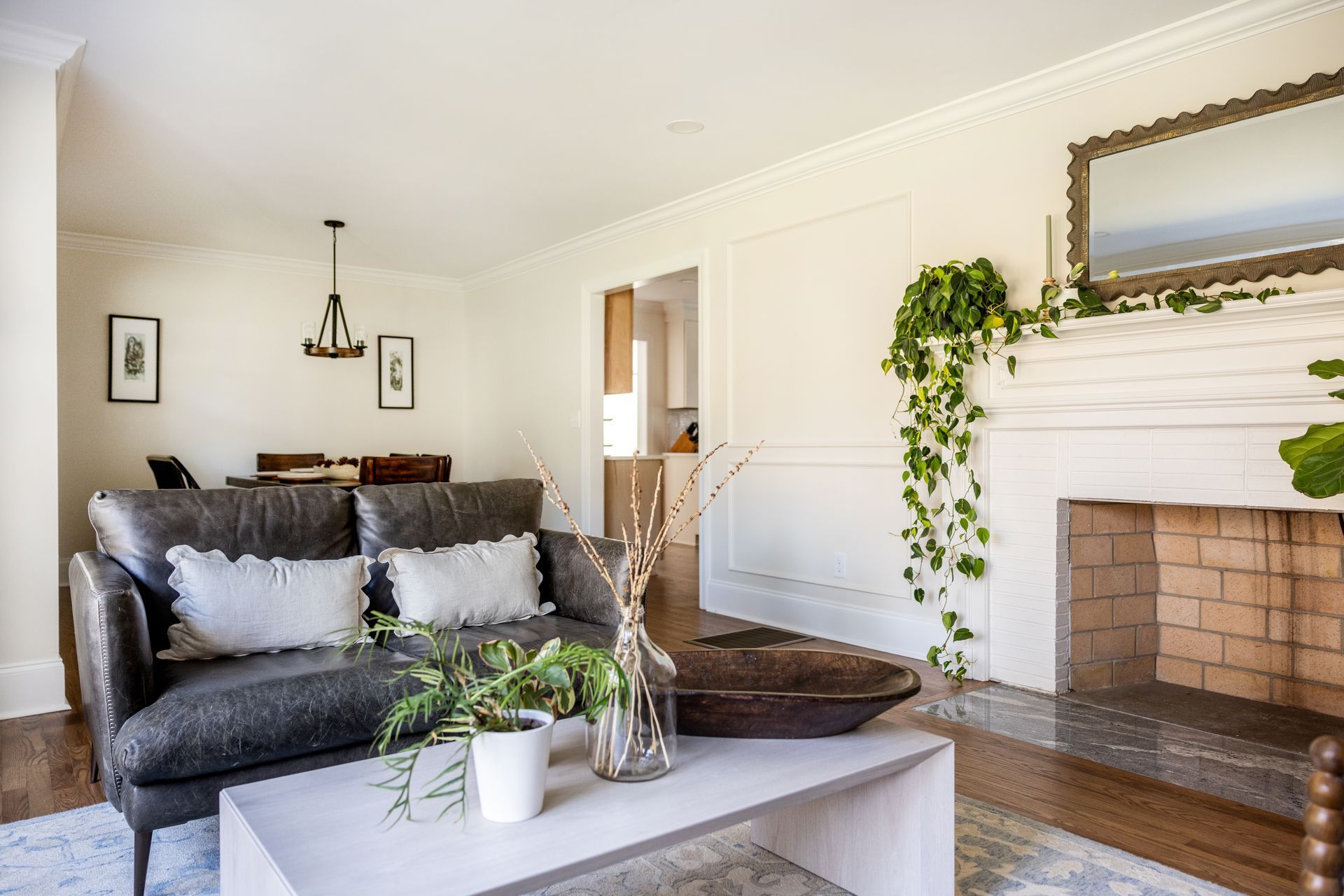 Living room with dark gray sofa, fireplace, and dining area.